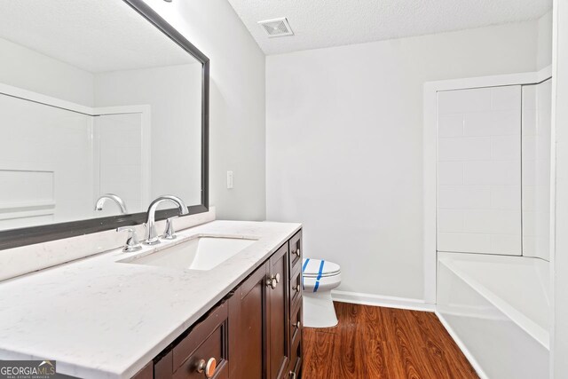 2199 Summertown Dr, Norcross, GA 30071 - bathroom with vanity, wood finished floors, toilet, a textured ceiling, and baseboards
