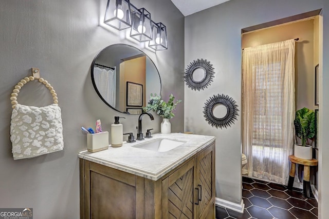 full bath with vanity, tile patterned flooring, toilet, and baseboards