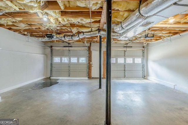 garage featuring baseboards, a garage door opener, and visible vents