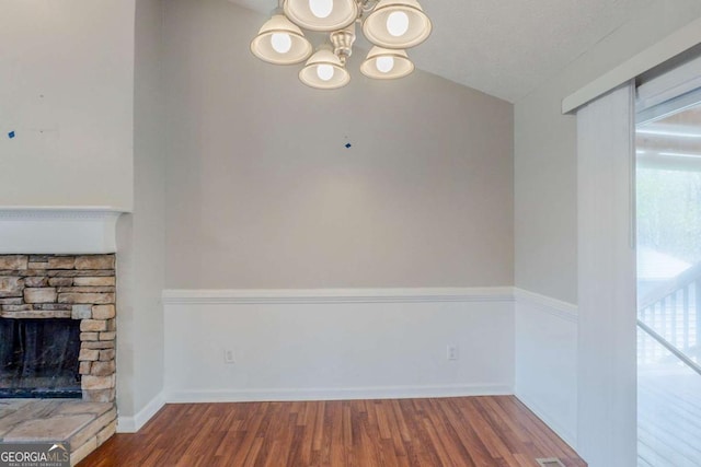unfurnished living room featuring plenty of natural light, baseboards, a fireplace, and wood finished floors