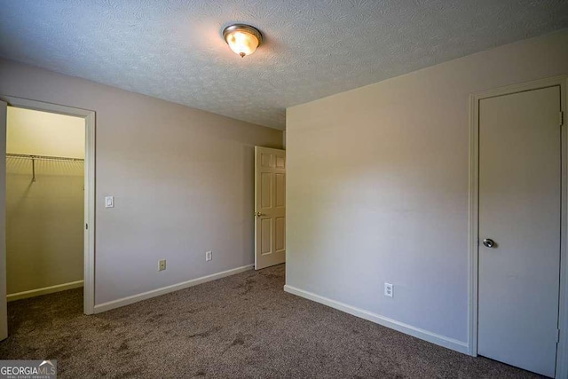 2048 Kelvin Dr, Lawrenceville, GA 30043 - unfurnished bedroom with a spacious closet, carpet floors, a textured ceiling, and a closet