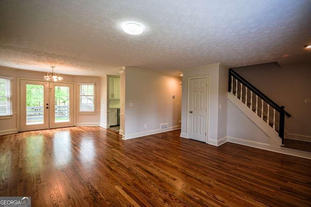 2048 Kelvin Dr, Lawrenceville, GA 30043 - unfurnished living room featuring a textured ceiling, a chandelier, dark wood-style floors, and stairs
