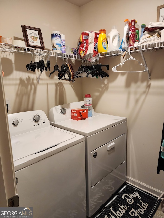 laundry area with baseboards, washing machine and dryer, and laundry area