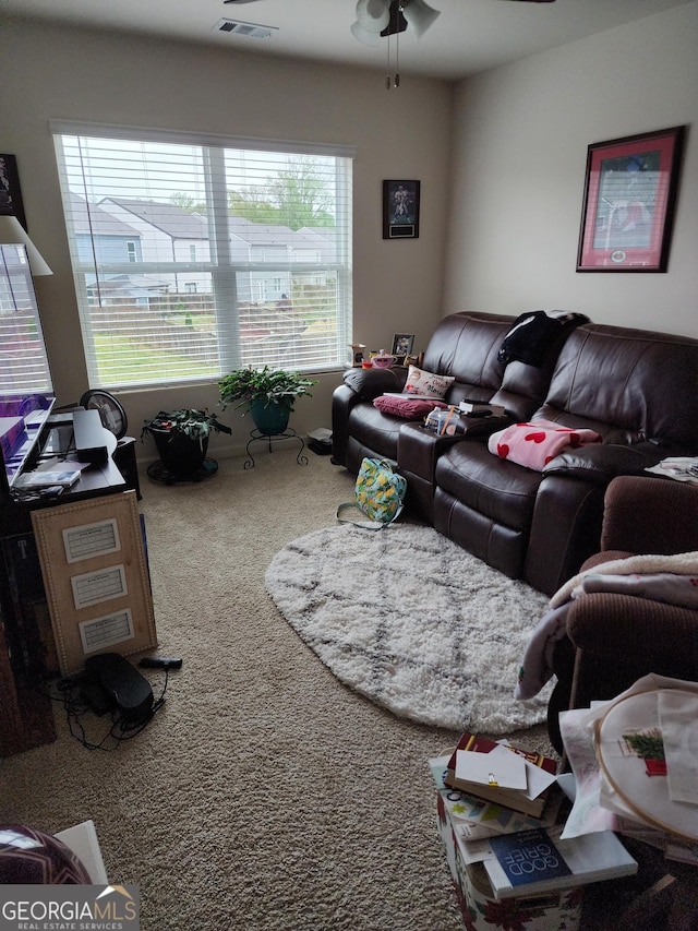 carpeted living room with visible vents and a ceiling fan