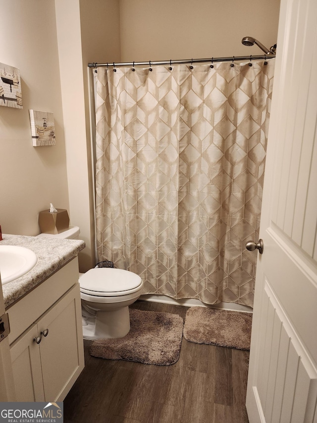 full bath with vanity, a shower with curtain, toilet, and wood finished floors