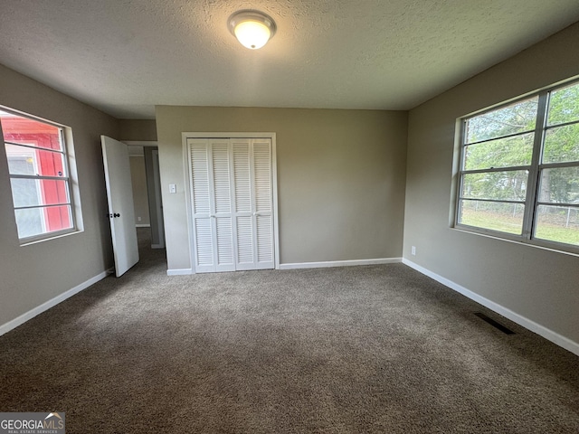 22 Spring Ave, Mcrae-Helena, GA 31055 - unfurnished bedroom featuring a textured ceiling, a closet, and carpet