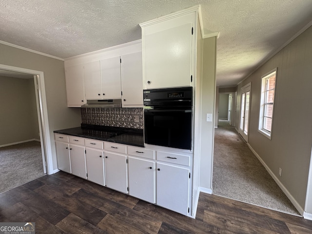 22 Spring Ave, Mcrae-Helena, GA 31055 - kitchen featuring black oven, under cabinet range hood, dark countertops, a textured ceiling, and ornamental molding