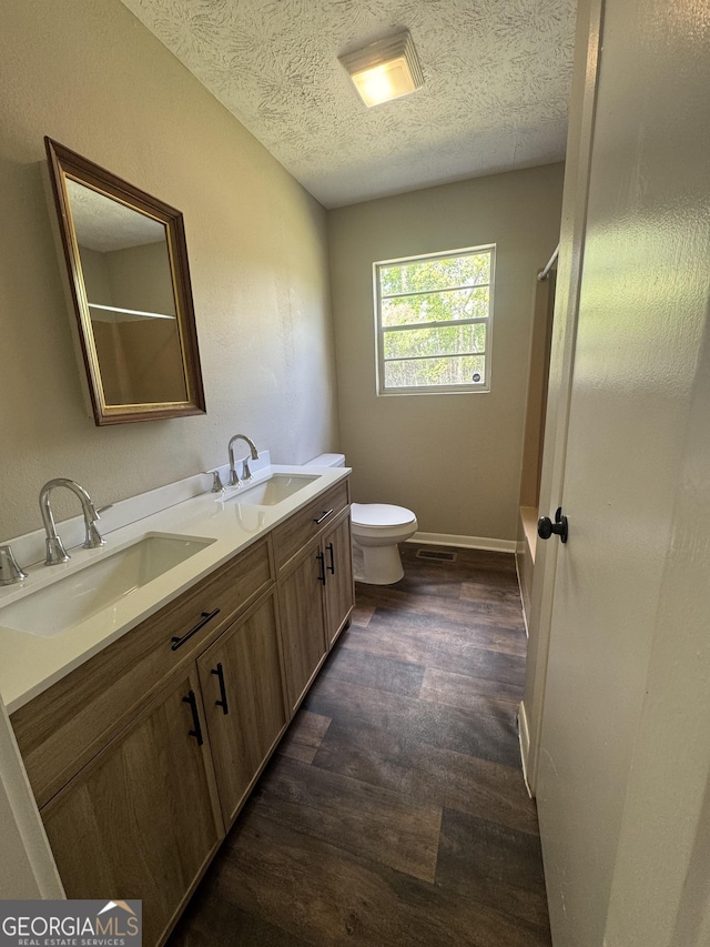 22 Spring Ave, Mcrae-Helena, GA 31055 - bathroom with wood finished floors, a textured ceiling, double vanity, and  shower combination