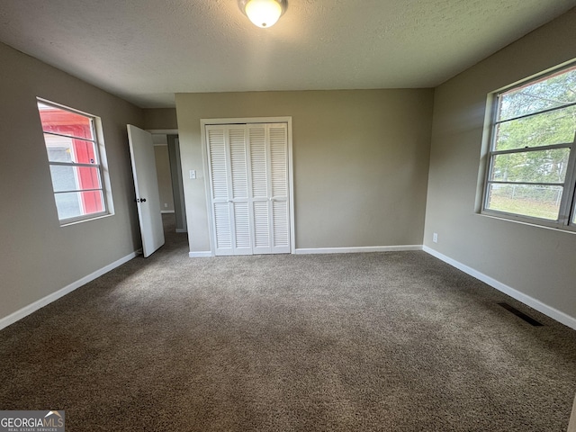 22 Spring Ave, Mcrae-Helena, GA 31055 - unfurnished bedroom featuring a closet, carpet flooring, and a textured ceiling