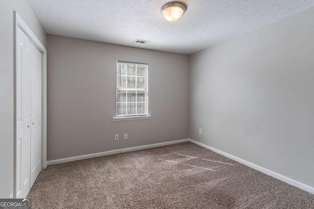 unfurnished bedroom featuring baseboards, carpet, a closet, and visible vents