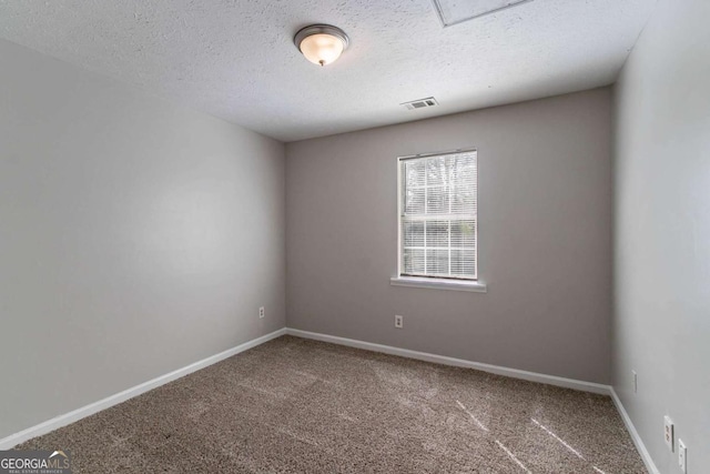 spare room with baseboards, visible vents, carpet flooring, and a textured ceiling
