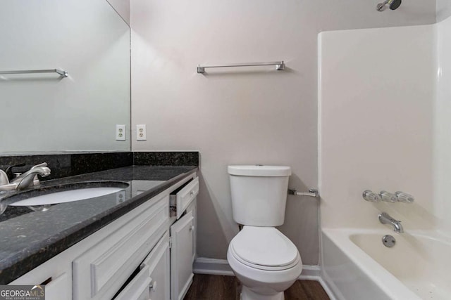 full bathroom with bathtub / shower combination, toilet, vanity, wood finished floors, and baseboards