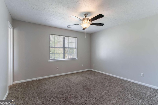 carpeted empty room with baseboards, a textured ceiling, ceiling fan, and visible vents