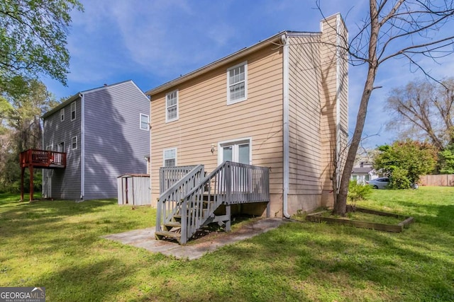 back of house with a lawn, a deck, and a chimney