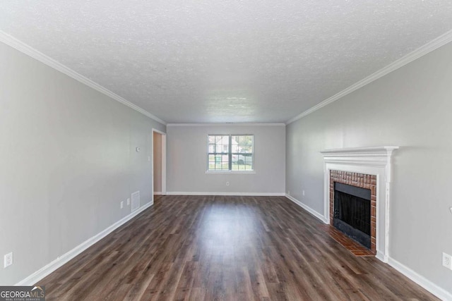 unfurnished living room with visible vents, a brick fireplace, baseboards, ornamental molding, and dark wood-type flooring