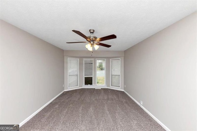 unfurnished living room featuring dark carpet, baseboards, and ceiling fan