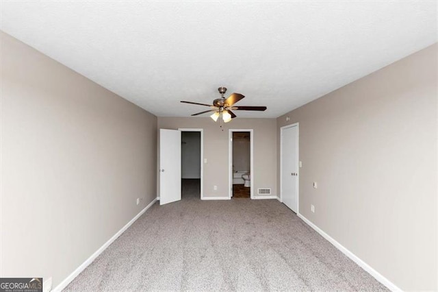 unfurnished bedroom featuring a textured ceiling, visible vents, baseboards, a ceiling fan, and carpet floors