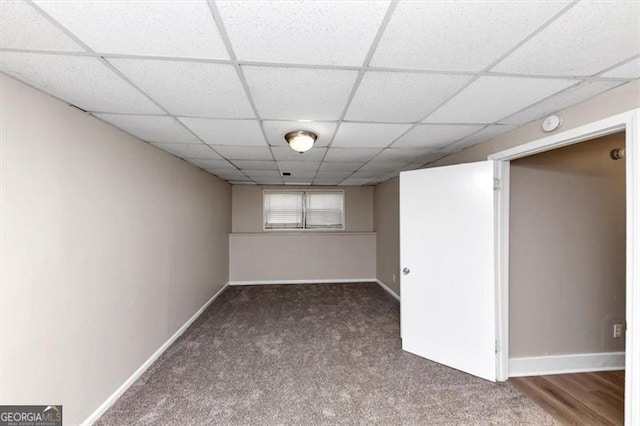 finished basement with baseboards, carpet floors, and a paneled ceiling