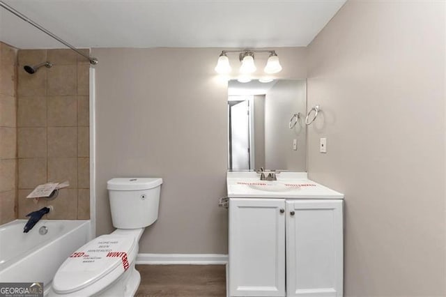 bathroom with baseboards, wood finished floors, toilet, and vanity