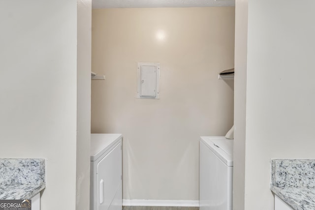 laundry room with laundry area, washing machine and dryer, and electric panel
