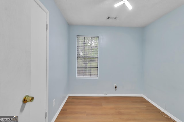unfurnished room with visible vents, baseboards, and wood finished floors
