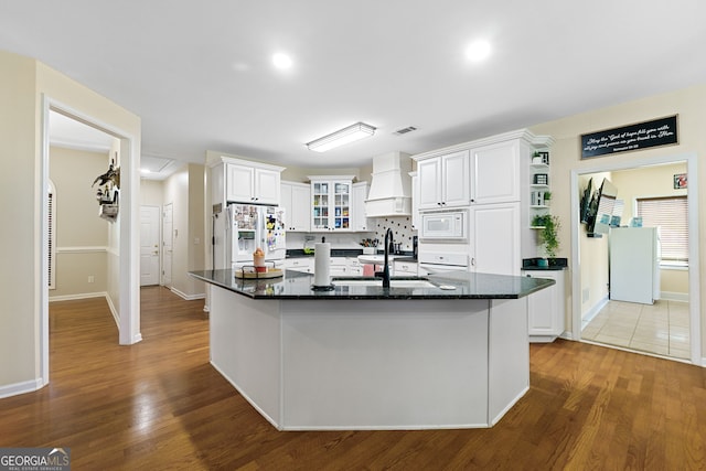 kitchen featuring premium range hood, a sink, white appliances, and white cabinets