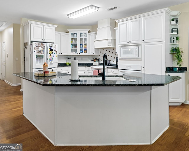 kitchen featuring custom exhaust hood, white appliances, dark wood-style floors, visible vents, and a sink