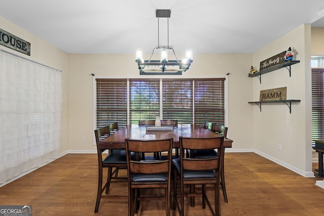 dining room with baseboards, a chandelier, and wood finished floors