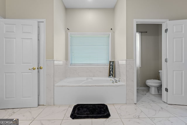 full bath featuring a wainscoted wall, marble finish floor, a garden tub, and toilet