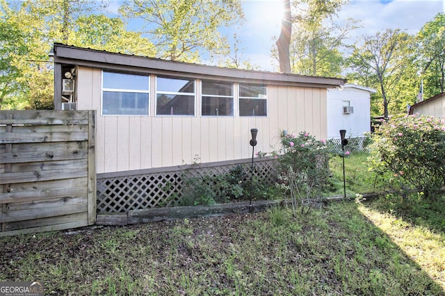 view of home's exterior featuring an outbuilding and fence