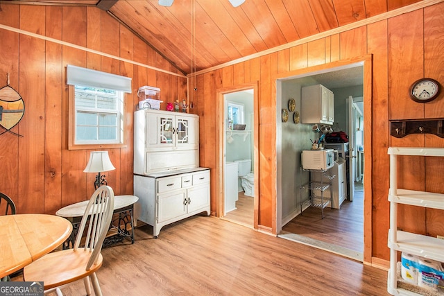kitchen with wooden walls, light wood finished floors, vaulted ceiling, and wood ceiling