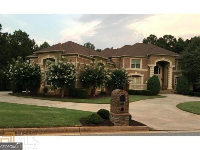 view of front of home with curved driveway and a front yard