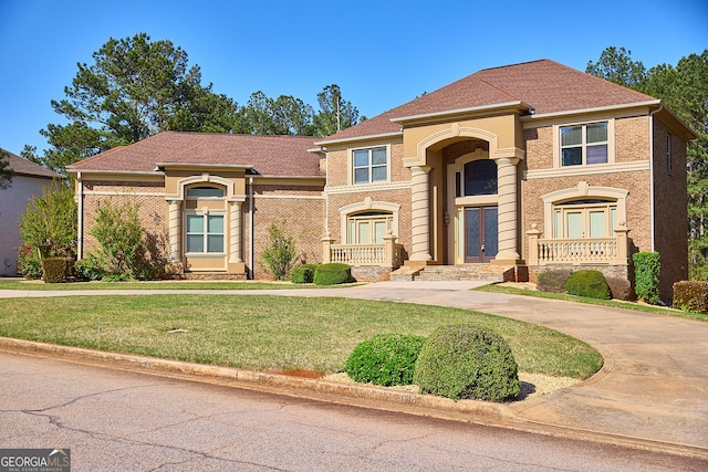 mediterranean / spanish-style house featuring curved driveway, french doors, and a front lawn