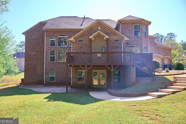 back of house with french doors, a deck, brick siding, a yard, and a patio