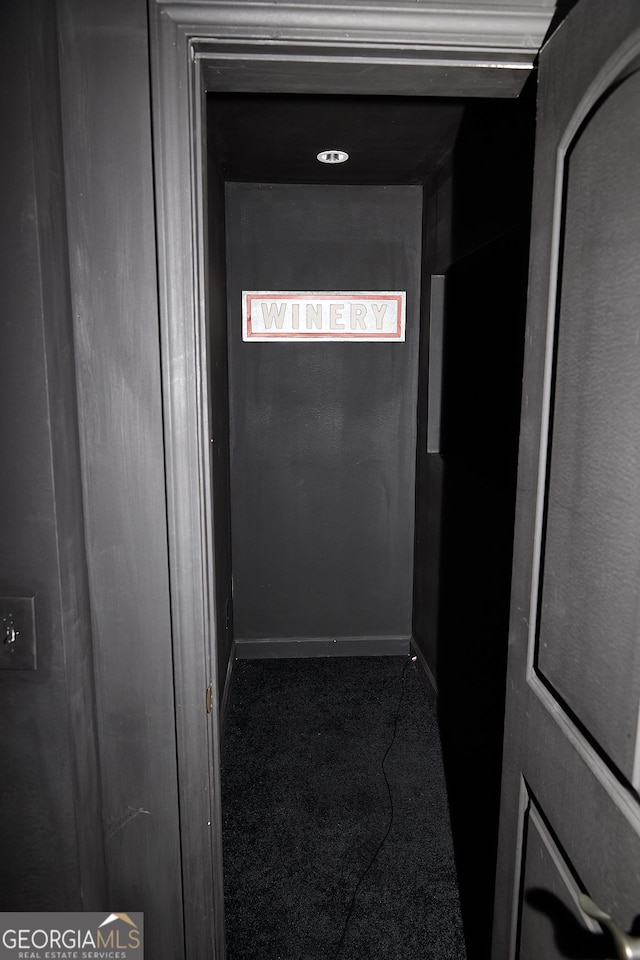 hallway with baseboards and carpet
