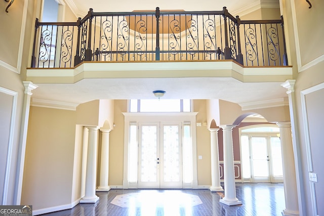 foyer featuring arched walkways, french doors, and wood finished floors