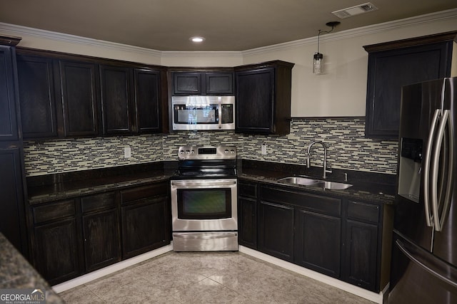 kitchen with crown molding, a sink, stainless steel appliances, decorative backsplash, and visible vents