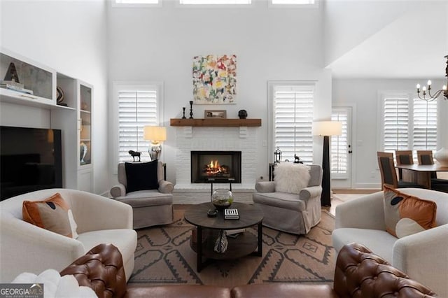 9 Grove Pointe Way, Cartersville, GA 30120 - living room with a high ceiling, a brick fireplace, a chandelier, and wood finished floors