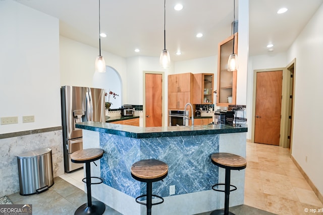 412 Trilium Trl, Pendergrass, GA 30567 - kitchen featuring stainless steel appliances, dark countertops, a kitchen bar, light tile patterned floors, and recessed lighting