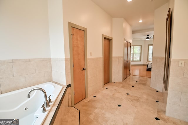 412 Trilium Trl, Pendergrass, GA 30567 - bathroom with a tub with jets, a ceiling fan, tile walls, recessed lighting, and a wainscoted wall