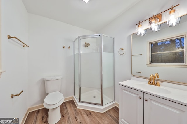 full bathroom featuring a shower stall, wood finished floors, vanity, baseboards, and toilet