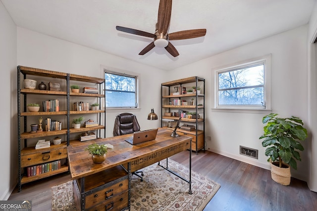 office space with wood finished floors, visible vents, a ceiling fan, and baseboards