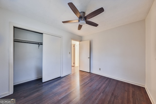 unfurnished bedroom featuring wood finished floors, a closet, and baseboards
