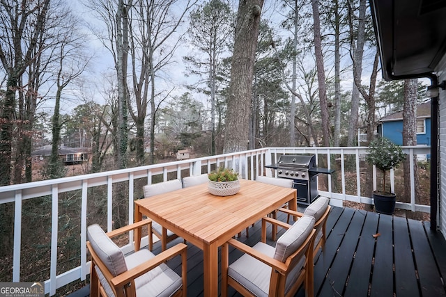 wooden terrace featuring outdoor dining space and a grill