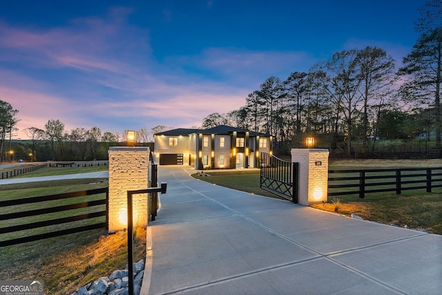 view of front facade with driveway, a gate, a lawn, a fenced front yard, and a garage
