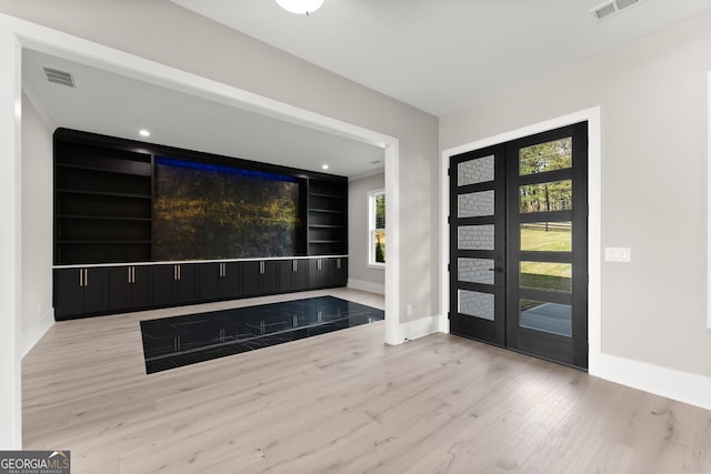 foyer entrance featuring baseboards, visible vents, wood finished floors, and french doors