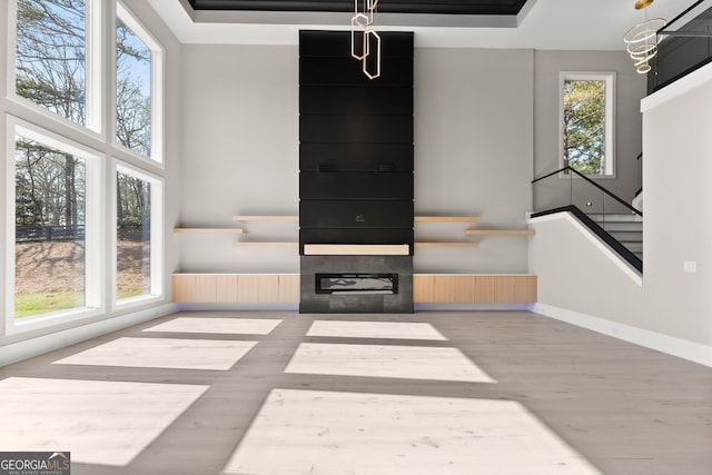 unfurnished living room with stairs, a wealth of natural light, and a high ceiling
