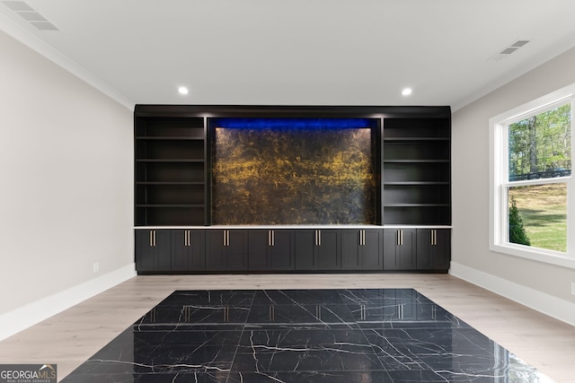 spare room featuring plenty of natural light, built in features, and baseboards