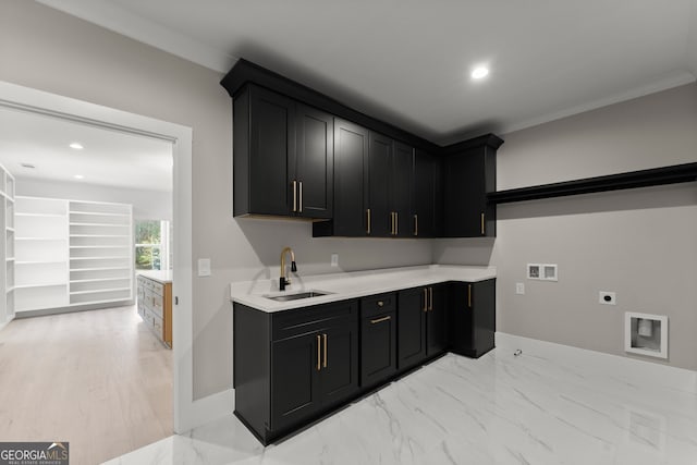 interior space featuring hookup for an electric dryer, hookup for a washing machine, marble finish floor, a sink, and cabinet space