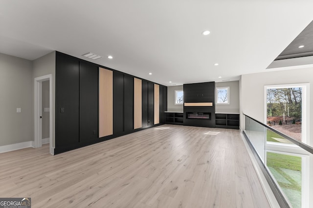 unfurnished living room with recessed lighting, baseboards, visible vents, light wood-style flooring, and a fireplace